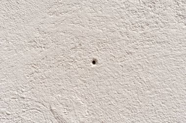 Delikli, krem renkli bir duvarın dokusu..