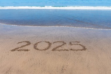 2025 'te kumsalda, deniz dalgası yaklaşırken yazılmış..