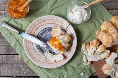 Reçelli, krem peynirli ve malzemeli kaseli bir tabağın üst görüntüsü..