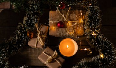 Noel hediyelerinin ve mum ışığıyla aydınlatılan süslemelerin en üst görüntüsü.