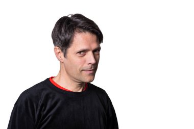 Beyaz arka planda, haylaz bir ifadeyle orta yaşlı bir adam, gündelik kıyafetler giyiyor..