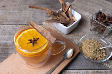 Papatya, tarçın, portakal ve anason çiçekleri karıştırılmış cam bardak..