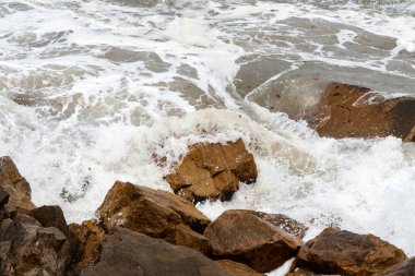 Deniz dalgaları kayalara çarpıyor..