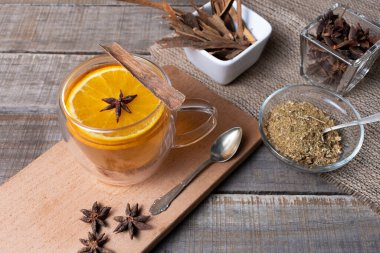 Papatya, tarçın, portakal ve anason çiçekleri karıştırılmış cam bardak..