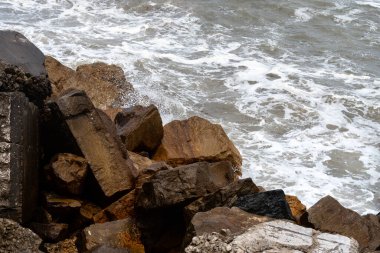 Deniz dalgaları kayalara çarpıyor..