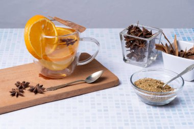 Papatya, tarçın, portakal ve anason çiçekleri karıştırılmış cam bardak..