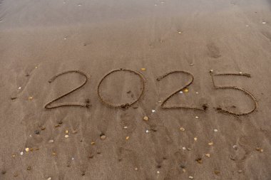 2025 plajdaki kumda yazılmış..
