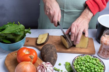 Pişirmek için patates ve diğer sebzeleri doğramak..