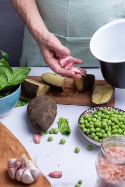 Yemek yapmak için diğer sebzelerin arasına sarımsak götürüyor..