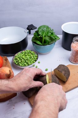 Pişirmek için patates ve diğer sebzeleri doğramak..