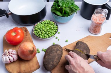 Pişirmek için patates ve diğer sebzeleri doğramak..