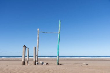 Güneşli bir günde, deniz kıyısındaki kumdaki bazı direkler ve taşlara odaklanın..