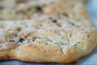 Fırınlanmış ıspanak ve taze malzemelerle dolu tabakta peynirli turta.