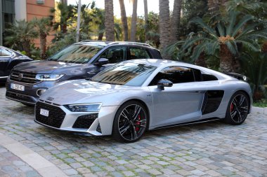 Monte-Carlo, Monaco - 16 Nisan 2023: Gri renkli Audi R8 Coupe V10 sergilenen Quattro Volkswagen Touareg SUV 'nin yanına park edilmiş, zıt otomotiv stilleri sergiliyor, Monako