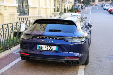 Monte-Carlo, Monaco - 16 Nisan 2023: Lüks mor Porsche Pansche Panamera 4S spor araba Monte-Carlo, Monaco 'da bir caddeye park edilmiş, aracın arka görüntüsü sergilenmektedir.