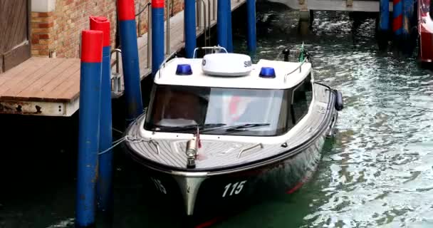 意大利威尼斯 2023年10月24日 黑色卡宾枪小艇 蓝色紧急信号灯 编号115 停泊在运河中的木制枕木上 这是在意大利威尼斯市执法的例证 Dci 4K视频 — 图库视频影像