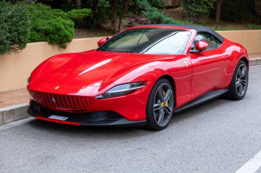 Monte-Carlo, Monaco - 9 Haziran 2024: Parlak kırmızı bir Ferrari Roma spor arabası sokağa park edildi. Lüks araç, parlak rengi ve zarif tasarımıyla, otomotiv mükemmelliği ve performansını gösteriyor..