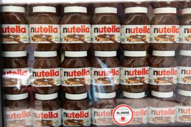 Nice, Fransa - 12 Haziran 2024: Bir dükkan vitrininde sıra sıra dizilmiş büyük bir Nutella kavanozu gösterisi. İkonik fındık ezmesi kavanozlarında belirgin bir şekilde Nutella markası ve ambalajı sergileniyor.