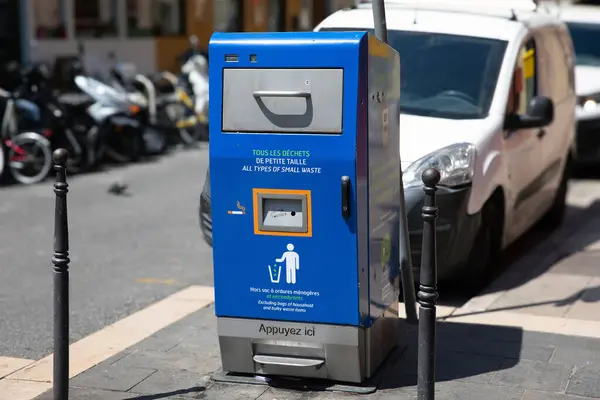 stock image Nice, France - June 12, 2024: A modern public waste compactor designed for small waste is installed on a street in Nice, France. The blue and gray unit is equipped with instructions in both French and English, encouraging proper waste disposal