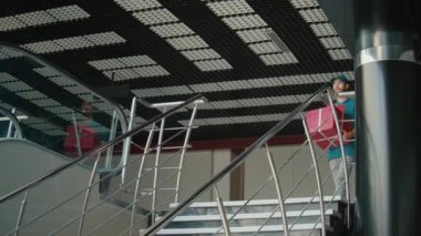 Modern Ofis Binası 'nda Merdivenlerden Aşağı Giderken İçinde Hediyenin Karton Kutusunu Getiren Üniformalı ve Termal Sırt çantalı Teslimatçı. Kurye, müşteriye sipariş vermeye gidiyor.