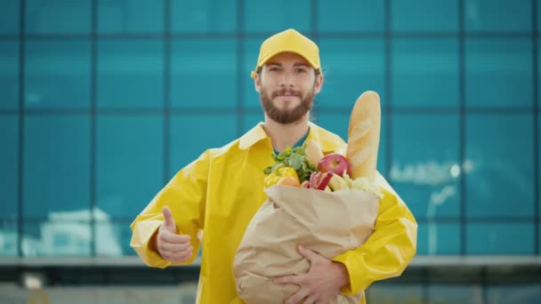 Portret Przystojnego Dostawcy Żółtej Jednorodnej Torbie Papierowej Żywnością Uśmiechnięty Kurier — Wideo stockowe
