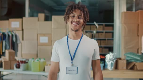 一个快乐迷人的年轻男性志愿者的画像 快乐的男人穿着一件白色T恤 带着相机 人道主义援助 捐助中心和志愿服务概念 — 图库视频影像