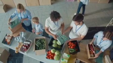 Üst Manzara. Sosyal Yardım Konsepti: Sevimli Genç Çocuk Dağıtım ve Mülteci Yardım Merkezi 'nde Gönüllülere Yardım Ediyor. Sadaka, Bağış ve Gönüllü Konsepti.