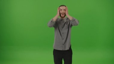 Denim Shirt Giyen Serbest Sakallı Genç Adam 'ın Portresi Elleriyle Kafasını Tutup, Yeşil Ekran' da Kazanan Jest Yapan Krom Anahtarlı Adam