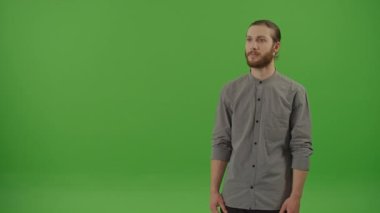 Kırmızı Hediye Kutusunda Yeşil Fiyonk ve Yeşil Ekranda Gülümseyen Hareketli Genç Sakallı Adam portresi, Chroma Key. Hediye ve Sürpriz Konsepti.