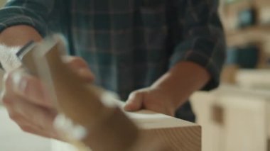 Zanaatkar Elleri Odun Çubuğunu Şekillendirmek İçin El Uçağı Kullanıyor 'un yakın çekimi. Marangoz bir marangoz atölyesinde proje üzerinde çalışıyor. El işçiliği. Marangozluk, İşçilik ve El İşi Konsepti.