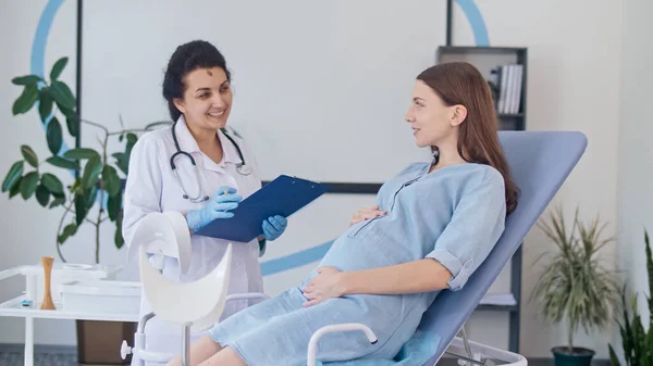 컨설턴트를 클리닉에서 산부인과 의사를 방문한다 의사는 임산부의 상태를 확인하기 임산부를 — 스톡 사진