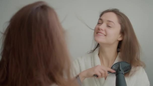 Powrót Widok Uśmiechniętej Kobiety Suszy Włosy Przed Lustrem Szczęśliwa Młoda — Wideo stockowe