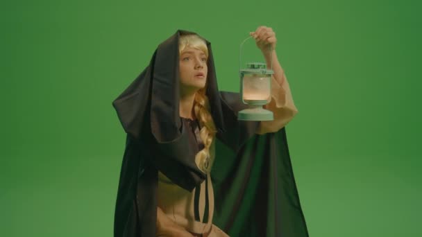 緑の画面 フード付きのクロークと中世のドレスを着たおとぎ話のような女性は ランプが暗闇を恐れています 魔法の森 神秘的で魅力的な世界 魔法の生き物 — ストック動画