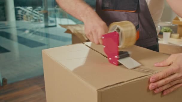 员工用胶带机密封纸板箱的特写镜头 专业的包装和拆装服务 搬运的包装和准备 包装物料及物料 — 图库视频影像