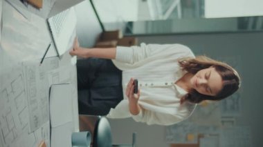 Dikey Video. Kendine güvenen kadın mühendis bir dizüstü bilgisayarda yeni bir proje üzerinde çalışıyor. Bayan Yönetici yeni bir proje yapıyor. Mühendislik ve Yaratıcılık Yeni Ürün Geliştirme