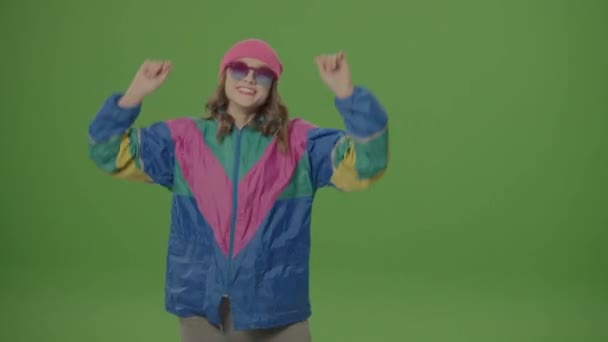 绿色屏风 90年代风格的女孩 戴着太阳镜和粉色帽舞表演一支舞 模仿节奏 人类情感的概念 情感的表达 心理状况 — 图库视频影像