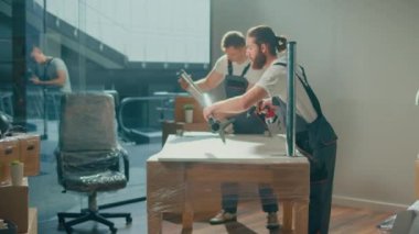 Üniformalı Taşımacılık İşçileri Mobilyaları Dikkatlice Paketliyor. Mobilya, ekipman sökme ve montaj. Seyahat sigortası. Çalışan İşçi Takımı Müşterilerin Taşımasına Yardım Ediyor.