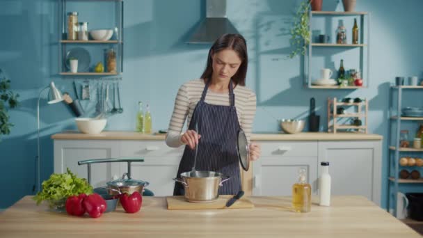 心烦意乱的年轻女子在家里的厨房里品尝被宠坏的饭菜 失望的家庭主妇在勺子上看着不好吃的粥 变质的配料 难吃的食物概念 — 图库视频影像