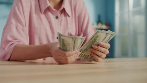 百ドルの銀行券のスタックを数える女性の手のクローズアップ ビジネスマンは家で現金を数えている 豊かさの概念 — ストック動画