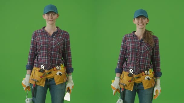 两对一的绿色屏风胶合 年轻自信的女土木工程师 身穿格子衬衫 头戴蓝帽 提起漆辊 喷漆向上 并对其进行对比 多夹最佳价值包 — 图库视频影像