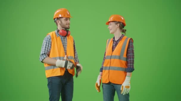 绿色屏风 年轻的男女工业专家穿着格子衬衫 工作服 有兴趣爱好的讨论项目 击拳和击掌 团队合作概念 — 图库视频影像