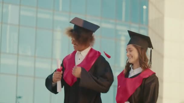 Випускники Joy Graduates Mantle Cap Diplomas Jumping Spinning While Walking — стокове відео