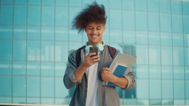 在校园背景下使用智能手机的有动机的年轻学生 他一边微笑一边给她的朋友或爱人留言 数字教育 未来技术专家E — 图库视频影像