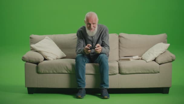 Πράσινη Οθόνη Ένας Γέρος Γκρι Γενειάδα Παίζει Ηλεκτρονικά Παιχνίδια Χειριστήριο — Αρχείο Βίντεο