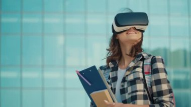 Üniversitenin arka planında VR kulaklık takan güzel öğrenci kız. Sanal Gerçeklik Öğrenme Konsepti. Öğrenmenin Robotlaştırılması. Dijital Eğitim. Eğitimde yenilikler. Gelecek Teknolojileri