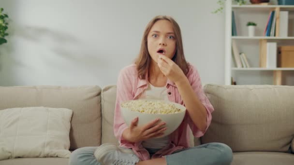 Young Woman Eating Popcorn Concentrating Watching Una Mujer Seria Sentada — Vídeos de Stock