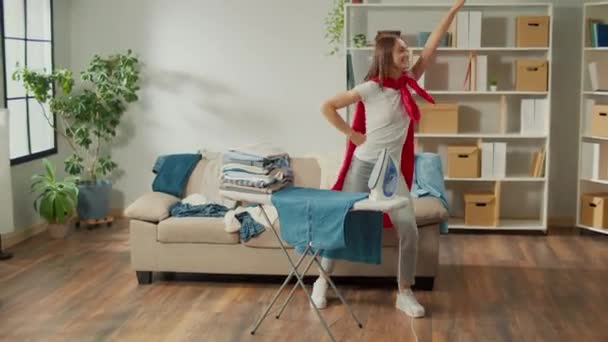 Happy Woman Housewife Super Hero Cape Dancing While Ironing Clothes — Vídeos de Stock