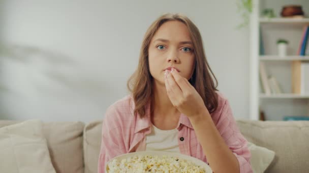 Μια Νεαρή Γυναίκα Τρώει Ποπ Κορν Και Συγκεντρώνεται Στο Βλέπει — Αρχείο Βίντεο