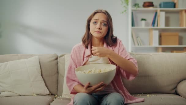 Ung Kvinna Som Sitter Soffan Och Äter Popcorn Och Tittar — Stockvideo