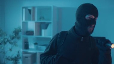 Siyah Giysili Soyguncu 'nun Yakın Çekimi ve Maske Eve Girdi. El feneri ve tabancası olan bir suçlu. Gece görüş gözetim kameraları. Kablosuz Gözetim Kameraları